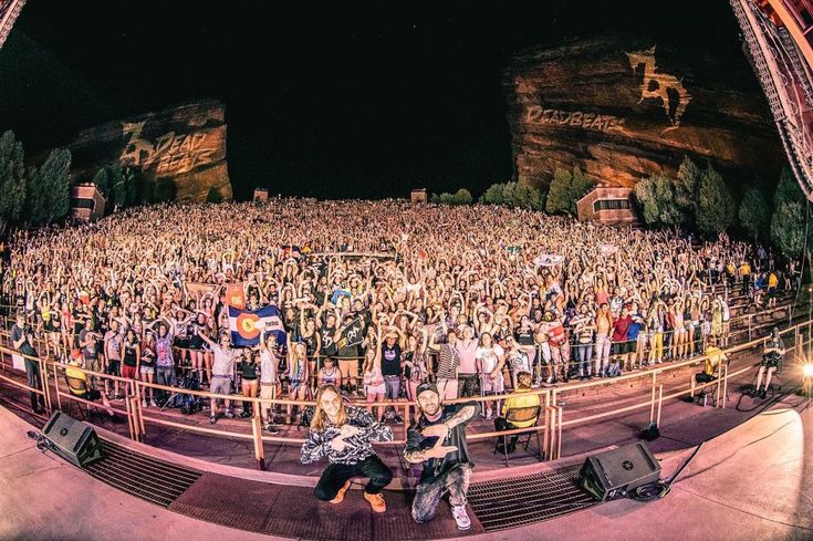 a group of people standing on top of a stage next to each other in front of a crowd