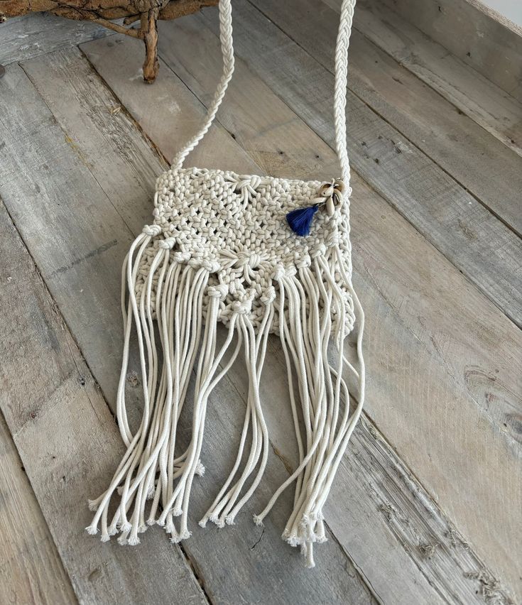 Beautiful handmade natural cotton fringe handbag in cream with sea shell feature on zip. The zip on the bag goes fully across so your items can be stored securely.  The size of the compartment is 18cm long by 20cm wide, able to store your phone lipstick and the essentials even some shells that you find on your way :) This is a small boho style shoulder bag perfect for any occasion. The strap length drop is 55 cm long 110cm in total. Cream Bohemian Shoulder Bag For Beach Season, Bohemian Cream Shoulder Bag For Beach Season, Bohemian Cream Beach Bag For Beach Season, Bohemian Crochet Bag With Tassels For Beach Season, Bohemian Straw Bag With Tassels For Beach Season, Bohemian Cream Straw Bag For Beach Season, White Fringed Shoulder Bag For Beach, Bohemian Straw Bag With Fringe For Beach, Bohemian Jute Crochet Bag For Beach Season