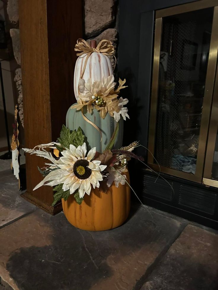 a pumpkin decorated with sunflowers and leaves