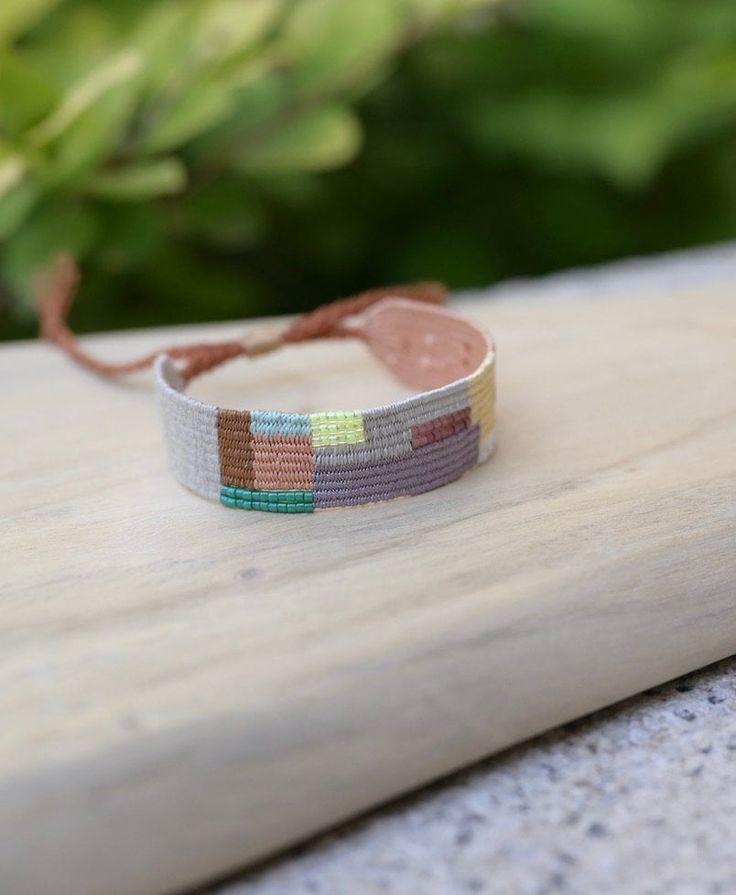 a close up of a bracelet on a wooden surface