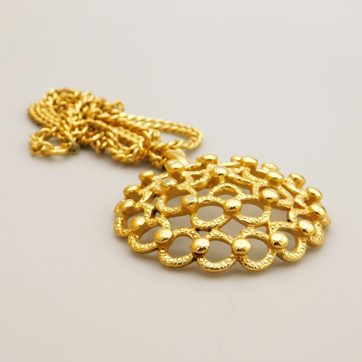 This vintage Monet pendant has an open metal work domed design.  Bead elements add depth and interest.  Pendant hangs on a nice curb link chain that is slightly over 1/8 inch wide and has a spring ring clasp.  The chain is 22 inches long and the pendant is about 2 inches in diameter.  Pendant is in very good vintage condition with some wear on the gold tone on about three of the beads. The chain has some dirty links but it looks like it could be cleaned off.  Signed Monet ©. Vintage Gold-tone Chain Necklace, Vintage Gold-tone Round Chain Necklace, Retro Round Metal Necklaces, Metal Pendant Chain Necklace With Curb Chain, Retro Round Metal Necklace, Vintage Gold Chain Necklace With Round Pendant, Metal Chain Necklace With Large Round Pendant, Gold Oval Pendant Metal Necklace, Gold Oval Pendant Chain Necklace