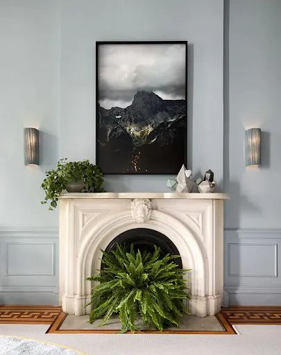 a living room with blue walls and a white fireplace