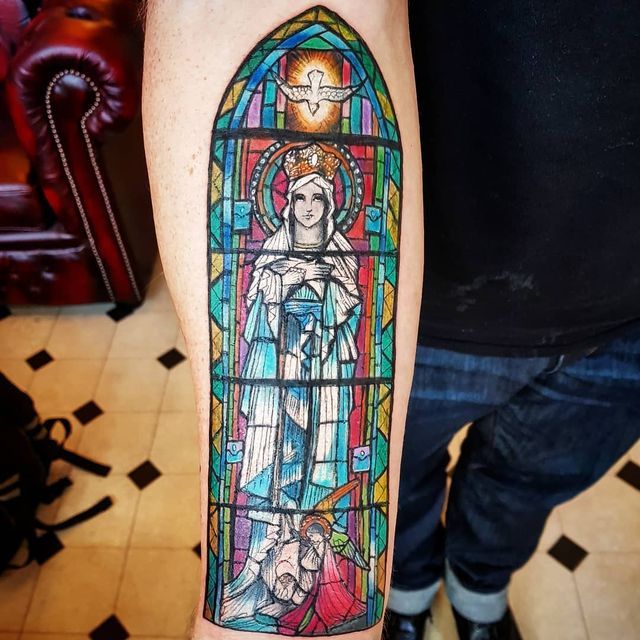 a stained glass window with the image of mary and jesus on it's arm