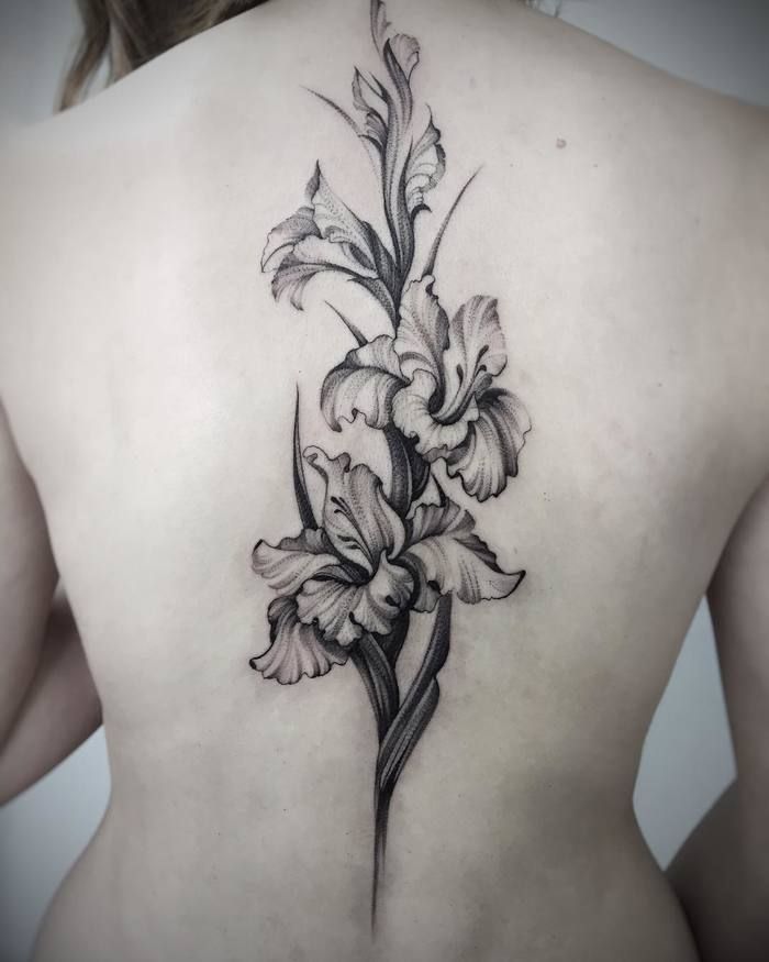 the back of a woman's body with flowers on her left shoulder and lower back