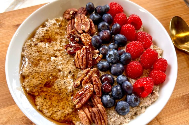 a bowl of oatmeal with berries and pecans