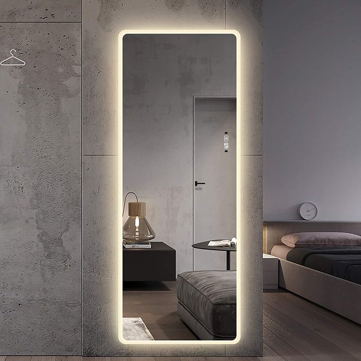 an illuminated mirror in the middle of a room with a bed and night stand next to it