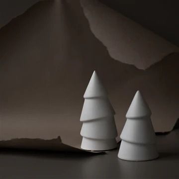 three small white trees sitting on top of a table