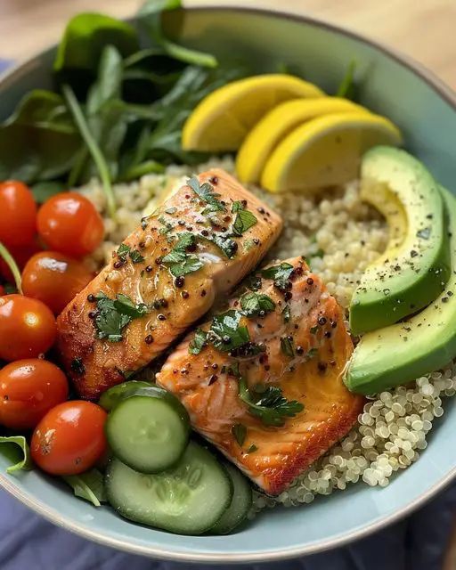 a bowl filled with salmon, cucumber, tomatoes, and other fresh vegetables