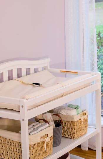 a white baby crib with baskets on it