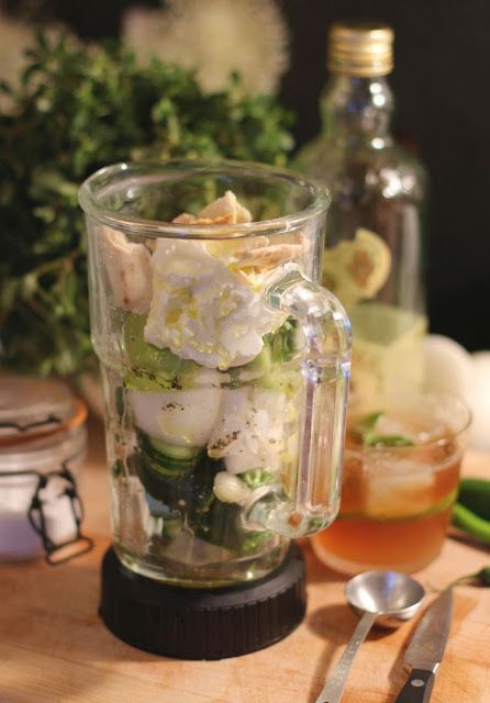 a blender filled with white flowers on top of a wooden table