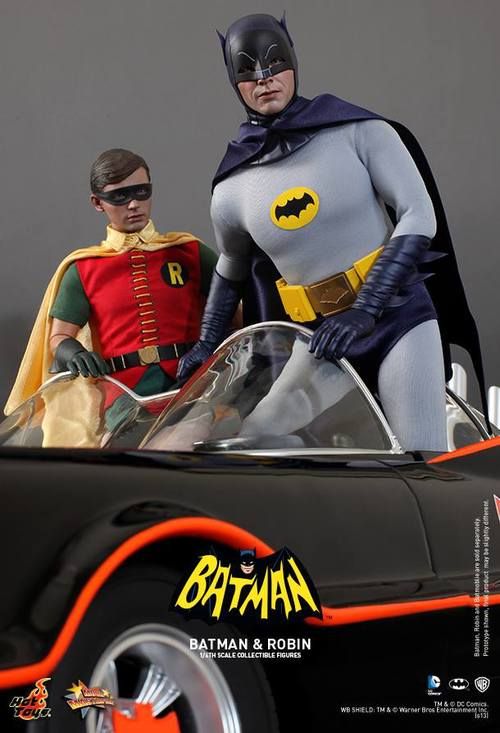 batman and robin wayne are standing next to each other in a toy car with the batmobile behind them