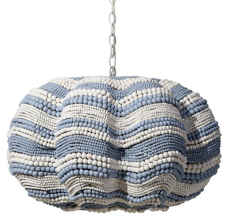 a blue and white beaded purse hanging from a metal chain on a white background