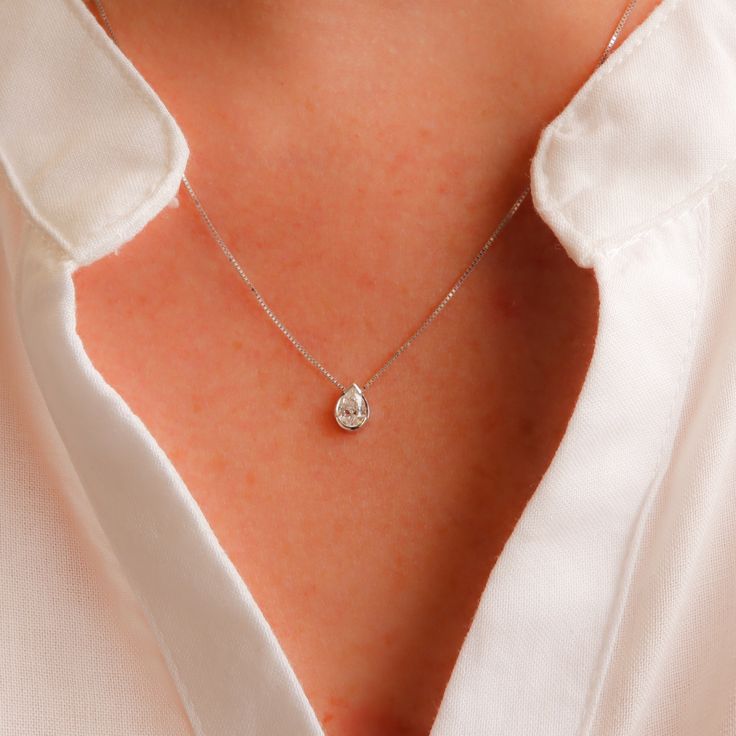 Introducing our Minimalist Floating Pear Diamond Necklace, a mesmerizing piece crafted in white gold. This exquisite necklace showcases a half-bezel setting, allowing the pear-shaped diamond to gracefully dance and capture the light from every angle. Its elegant and dainty design exudes a timeless allure, making it the perfect accessory for any occasion. Available in both 14k and 18k white gold, this necklace is a symbol of sophistication and class. Elevate your style and indulge in the beauty o Teardrop Diamond Necklace With Prong Setting For Wedding, Wedding Diamond Necklace With Teardrop Pendant, Teardrop Pendant Diamond Necklace With Prong Setting For Wedding, Elegant Teardrop Solitaire Necklace For Anniversary, Wedding Teardrop Pendant Diamond Necklace With Prong Setting, Elegant Teardrop Pendant Solitaire Necklace For Anniversary, Elegant White Teardrop Solitaire Necklace, Fine Jewelry Solitaire Drop Necklace With Prong Setting, Teardrop Brilliant Cut Solitaire Necklace For Wedding