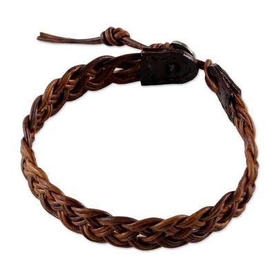 a brown braided leather bracelet on a white background