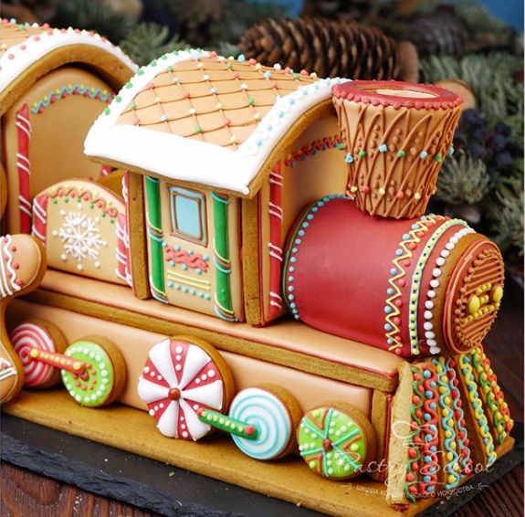 a close up of a gingerbread train with candy decorations on the front and sides