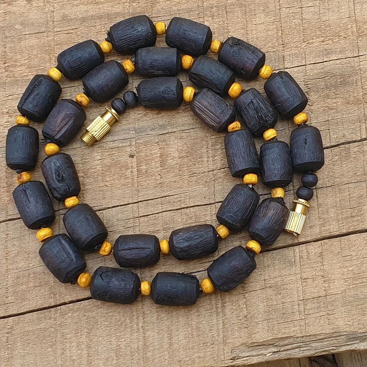 📿Necklace handcrafted with Black Shaded Tulsi Beads perfectely complimeted with rondelle Beige shaded tulsi beads. Tulsi Necklace is beneficial for people who have scattered minds and erratic behaviours, as it helps to keep the wearer focussed. 📿 🚪 NECKLACE DETAILS 🚪 📏Mala Beads size: 14 mm (Cylindrical) x 10 mm (Round) (Approx) 📏Mala Necklace Length: 19 inches 📏One Round 🚪 Pure Tulsi Beads Sourced from Vrindavan 📿 TULSI BEADS PROPERTIES 📿 🌹 Enormous physical healing powers 🌹 Rejuven Spiritual Black Necklace With Large Beads, Spiritual Black Necklaces With Large Beads, Black Spiritual Necklaces With Large Beads, Black Amulet Necklace With Polished Beads, Black Amulet Necklaces With Polished Beads, Black Amulet Style Necklaces With Polished Beads, Black Round Beads Jewelry For Rituals, Handmade Black Necklaces For Rituals, Traditional Black Jewelry With Wooden Beads