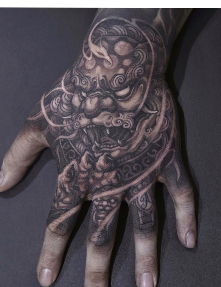 a man's hand with tattoos on it