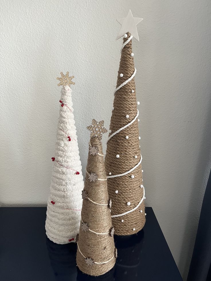 three small christmas trees sitting on top of a black table