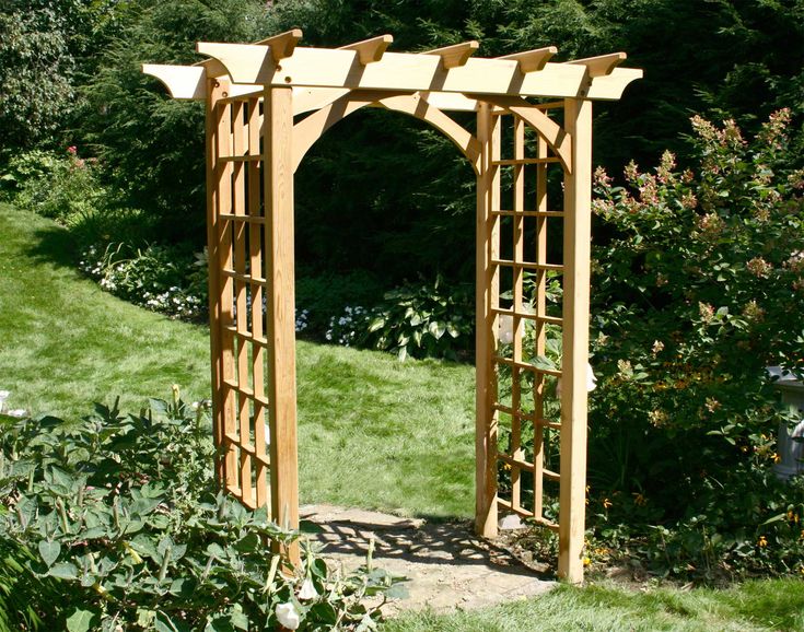 a wooden arbor in the middle of a garden