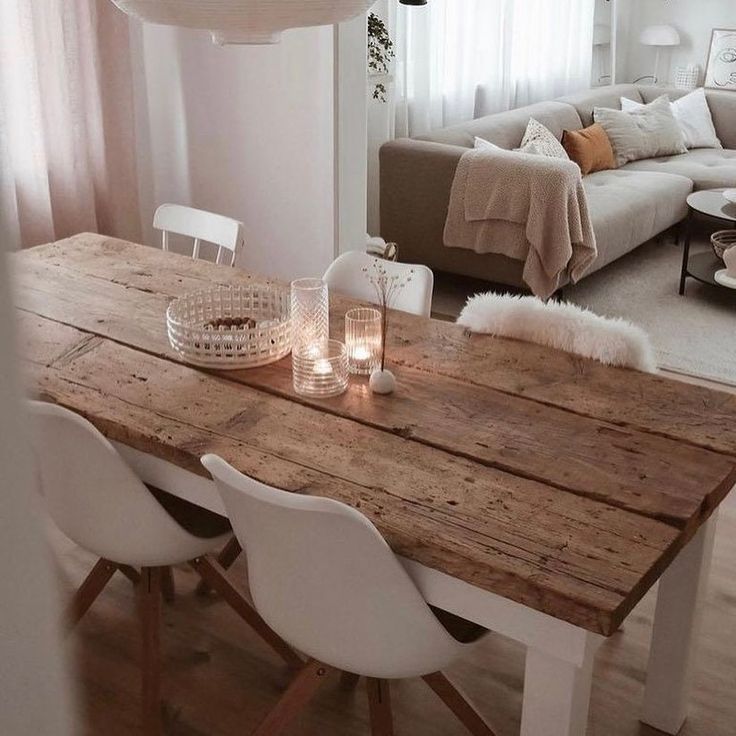 a wooden table with white chairs and candles on it