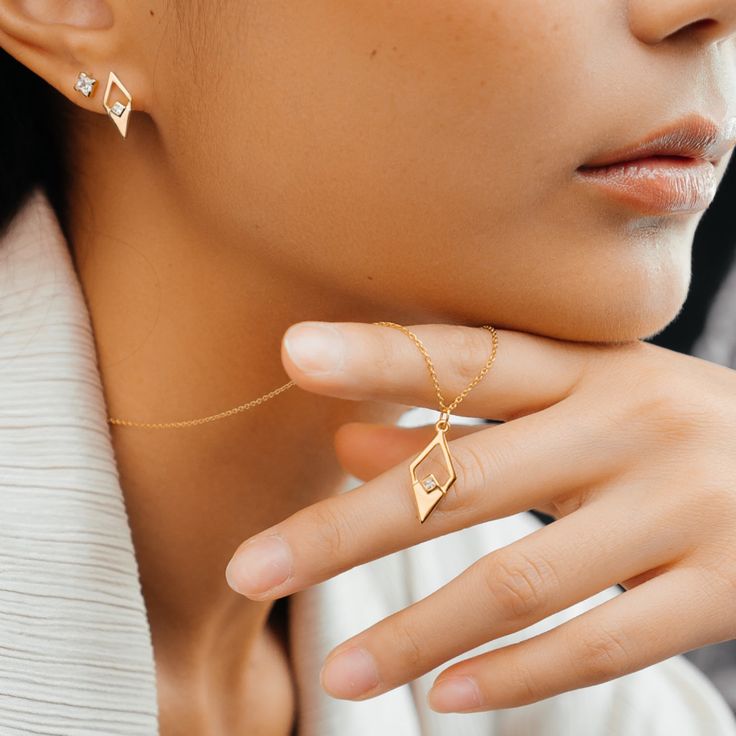 This stunning necklace features a sleek and modern design, crafted from recycled 14ct gold vermeil for a luxurious finish. The geometric pendant showcases a unique diamond shape, adding a bold touch to any outfit. Suspended from a delicate gold chain, the pendant elegantly frames a central accent, making it a perfect statement piece for both day and night.   Available in sterling silver & 14ct gold vermeil. Designed in the UK Crafted in recycled 14ct gold vermeil Cubic zirconia Lobster clasp fas Modern Square Pendant Necklace With Diamond Cut, Modern Diamond Cut Square Pendant Necklace, Modern Necklace With Diamond Cut For Gifts, Modern Necklaces With Diamond Cut For Gifts, Modern Diamond Necklace For Gifts, Modern Diamond Cut Necklace As A Gift, Modern 14k Gold Diamond Necklace Gift, Modern Diamond Necklace For Anniversary, Modern Diamond White Jewelry With Diamond Cut