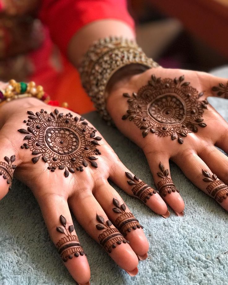 two hands with henna designs on them