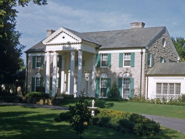 a large house with columns and green shutters