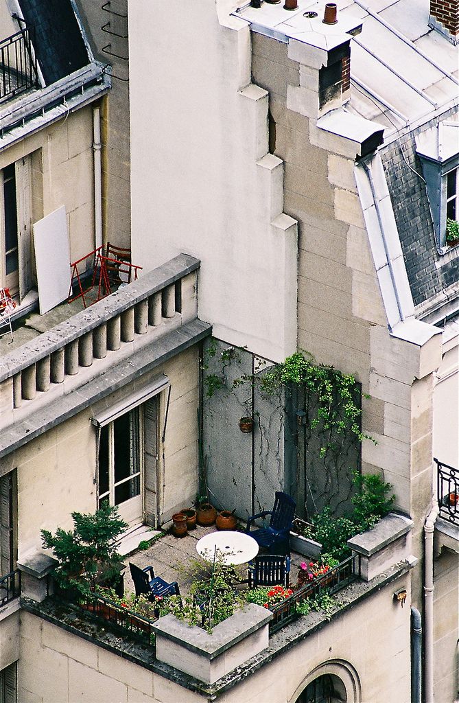 an aerial view of the roof of a building with plants growing out of it's balconies