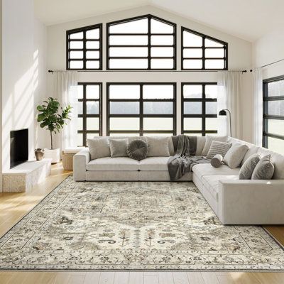 a large living room with white furniture and windows in the wall, along with hardwood flooring