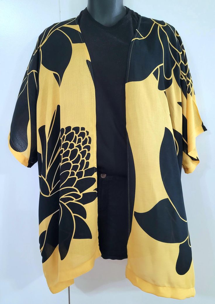 Hawaiian Aloha wear.  Kimono style cardigan cover-up top.  Black on yellow, ALI'I TORCH GINGER print.  Perfect island wear--Cool and comfortable island, dress up or dress down, for an evening out, office attire, or a day at the beach.  Hand made in Hawaii.  Light weight 100% rayon.  One size fits most,  suggest Medium to 2x Mannequin in the photo is a size x-small.  Hand wash and hang to dry. Summer Bohemian Yellow Cardigan, Yellow Bohemian Cardigan For Summer, Casual Tops With Kimono Sleeves For Vacation, Yellow Cardigan For Beach During Spring, Yellow Cardigan For Spring Beach Occasion, Yellow Summer Cardigan For Day Out, Yellow Spring Cardigan For The Beach, Spring Yellow Beach Cardigan, Yellow Spring Beach Cardigan