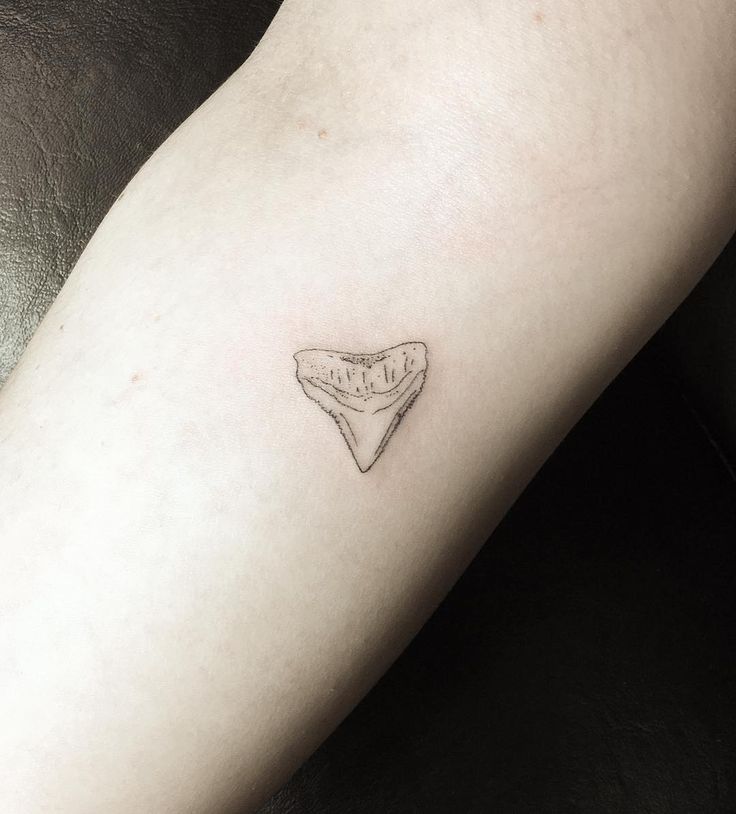 a small tattoo on the leg of a woman's left arm that has a piece of bread in it