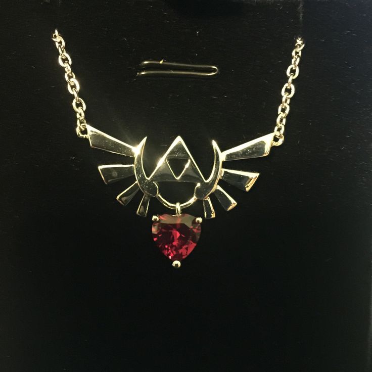 a necklace with a red stone in the shape of a bird on it's back