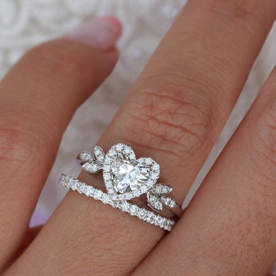 a woman's hand with two wedding rings on it and one diamond ring in the middle