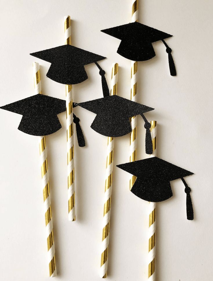 graduation decorations made out of straws with black caps and tassels on them