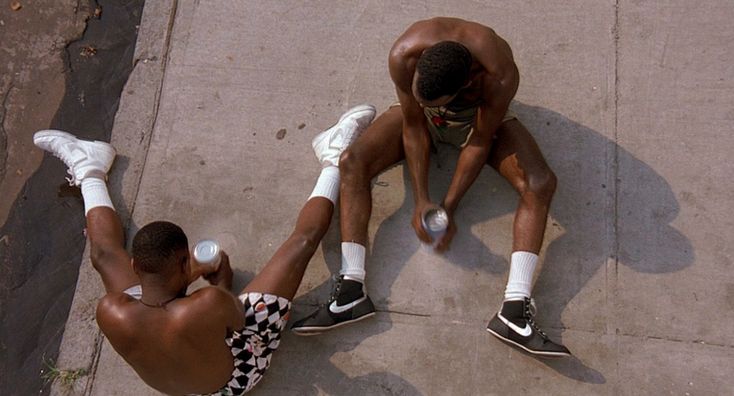 two men sitting on the ground with their feet up