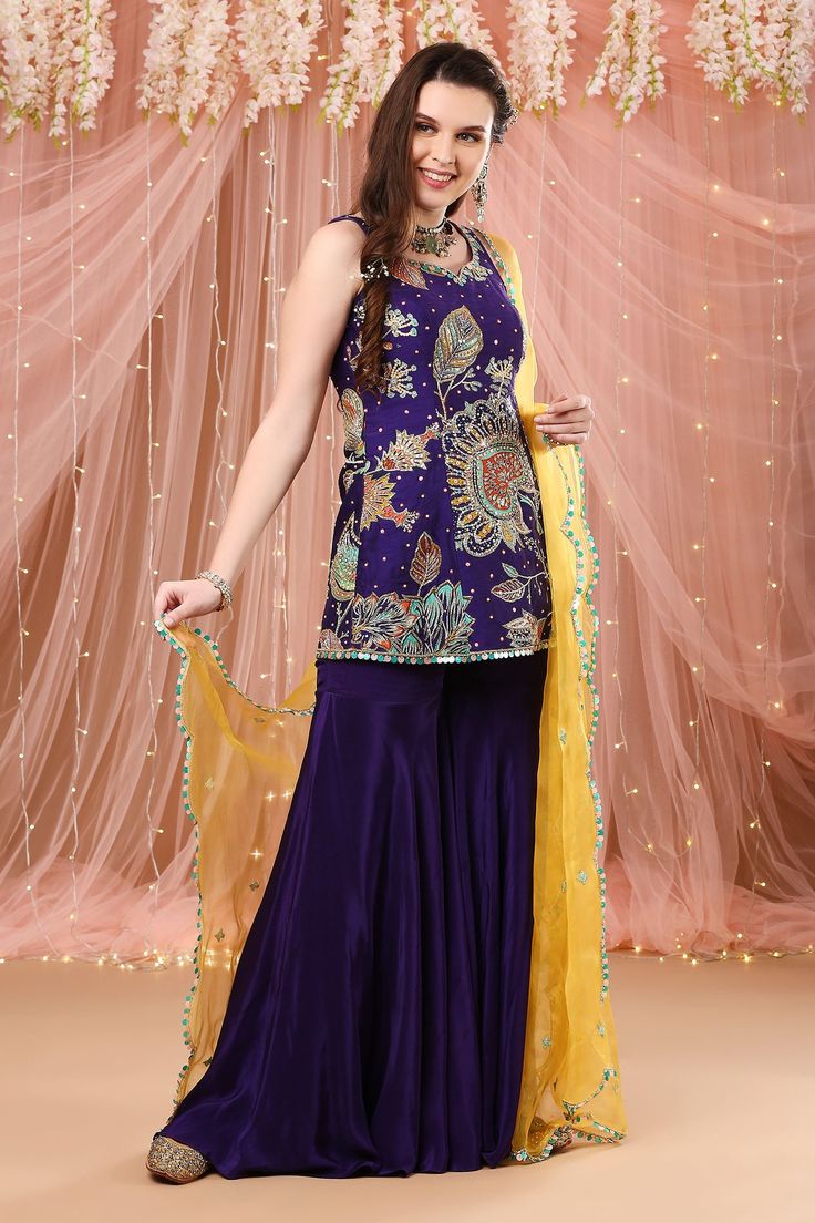 Purple raw silk  floral embroidered kurta in zardozi work. Paired with solid gharara and dupatta.
Component: 3
Pattern: Embroidered, Printed
Type Of Work: Zardozi work, Floral print
Neckline: Leaf neck
Sleeve Type: Sleeveless
Fabric: Raw silk, Crepe silk, Organza
Color: Purple 
Other Details: 
Sequin hem kurta
Contrast dupatta
Occasion: Reception - Aza Fashions Contrast Dupatta, Zardozi Work, Silk Organza, Fashion App, Silk Crepe, Embroidered Silk, Raw Silk, Set For Women, Aza Fashion