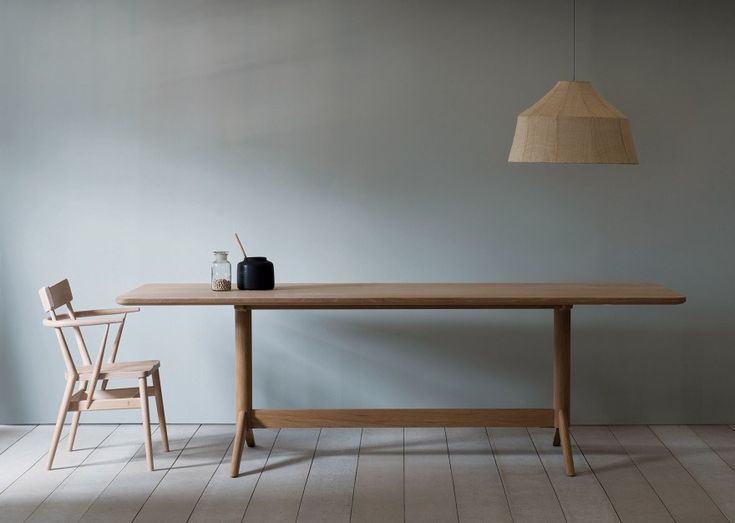 a wooden table with two chairs next to it and a lamp hanging from the ceiling