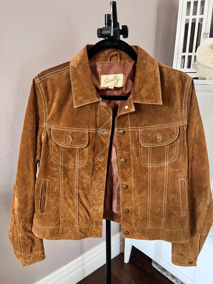 Timeless, practical and beautiful.  Few things say style like a western style real suede jacket, and this one is a beauty!  Soft yet hearty and fully lined, it looks like its never been worn.  Scully brand and fully lined in brown satin. Size XL means it WILL FIT, and if you like the bulky feel, you will have room for a sweater, hoodie or flannels.   Please message if you need exact measurements. Fall Suede Leather Jacket With Suede Lining, Brown Leather Jacket With Suede Overlays, Fitted Suede Leather Jacket With Pockets, Brown Suede Leather Jacket For Spring, Western Brown Fitted Leather Jacket, Leather Outerwear For Fall, Western Style Fitted Leather Jacket For Fall, Fitted Leather Outerwear For Rodeo, Fall Ranch Leather Outerwear