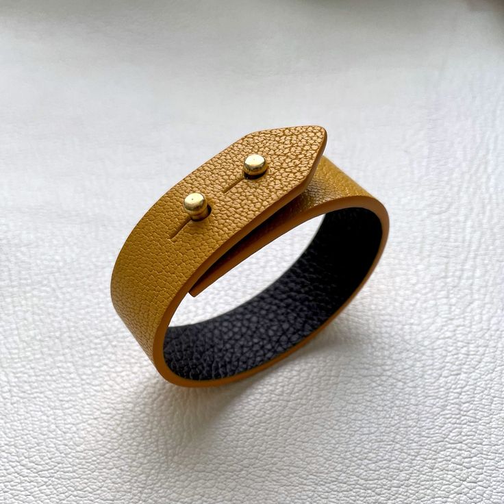 Beautiful leather bracelet. Simple, classy design, easy to style.  Bracelet is fully handcrafted, made from very finest French goat leather with buttery smooth surface. It also has a leather lining. Edges are polished and painted so it's comfortable on wrist.  Total length - 20.5 cm Wrist size - 15.5 cm (size S) Width - 2 cm Thickness - 2 mm Hardware - Brass / Gold Colour Leather Color - Yellow  Leather Type - Goat Leather Lining - Dark Brown Item is ready to ship so You don't need to wait! If You have any questions or You need any other size feel free to contact me :) Classic Leather Bracelets For Everyday, Minimalist Formal Bracelet With Leather Strap, Minimalist Leather Strap Bracelets For Formal Wear, Minimalist Leather Strap Bracelet For Formal Occasions, Classic Everyday Leather Bracelet, Minimalist Leather Bracelets With Leather Strap, Everyday Leather Wristband With Bracelet Strap, Everyday Leather Wristband With Leather Strap, Everyday Leather Wristband With Strap