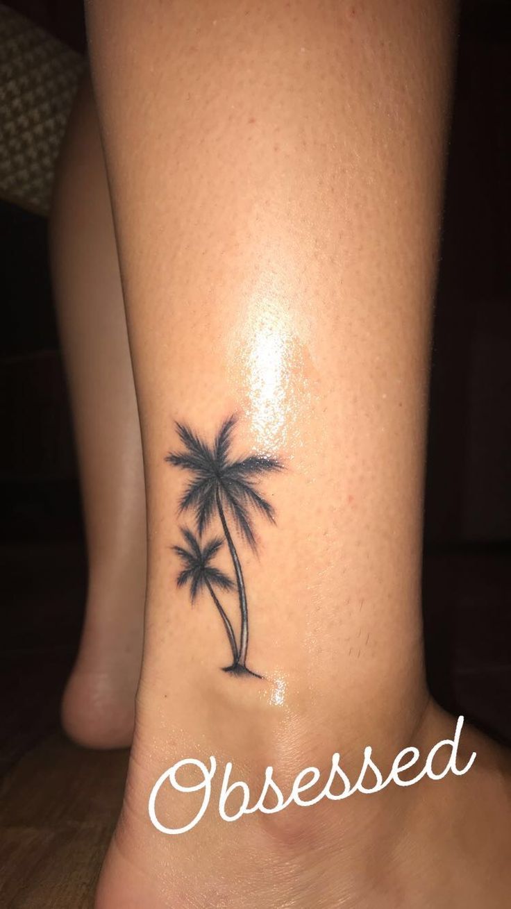 a small palm tree tattoo on the side of a woman's foot that reads, classied