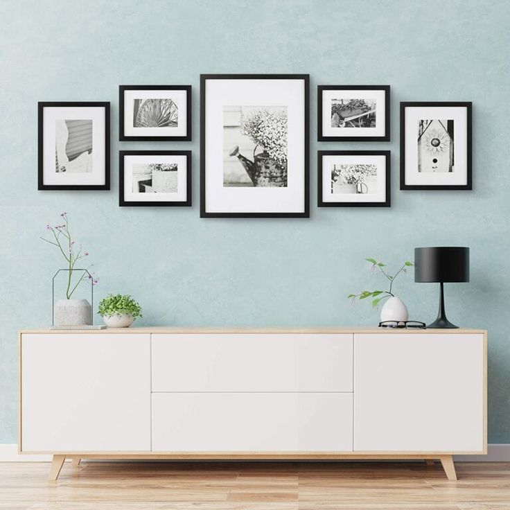 a living room scene with focus on the sideboard and pictures hanging on the wall