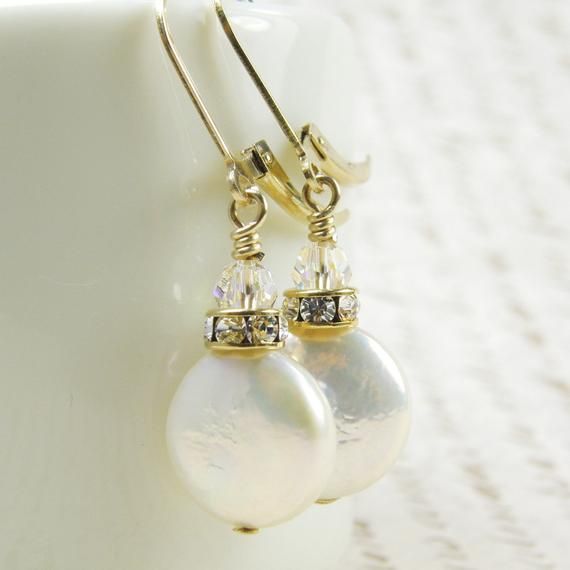 Beautiful pearl earrings are handmade with iridescent white coin pearls. Shaped liked little discs, these pearls are grown naturally from oysters seeded with a tiny disc shaped object. Perfect luster and polish on these coin pearl earrings. Accented with a Swarovski rhinestone crown and sparkly crystal. Dangles gracefully on 14k gold filled leverback earring closures.A great gift for a woman born in June since pearl is her birthstone.Earring Details:- Coin pearls are 12 mm- Pearl earrings are ju Handmade Pearl White Pearl Earrings, Baroque Pearl Earrings Gift, Anniversary Pearl Earrings With Pearl Charm, Handmade Round Baroque Pearl Earrings, Baroque Pearl Wedding Jewelry With Ear Wire, Baroque Pearl White Pearl Earrings For Anniversary, Wedding Pearl Drop Earrings In Mother Of Pearl, Handmade Pearl Earrings For Anniversary, Gift Pearl Earrings With Ear Wire