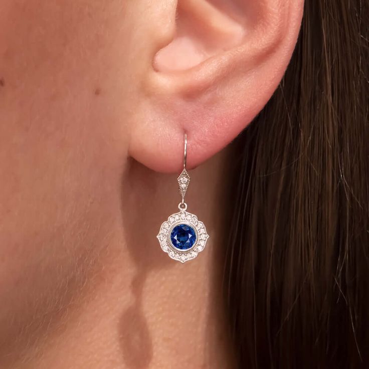 These elegant and brilliantly sparkling sapphire and diamond earrings bring the glamour with a chic and sophisticated Art Deco style design! The halo design glitters with 0.22ct of vibrant natural diamonds and perfectly set off the rich blue sapphires. Graceful and luxurious, these timelessly gla... Blue Diamond Drop Earrings For Anniversary, Gia Certified Sapphire Diamond Earrings For Formal Occasions, Formal Gia Certified Sapphire Diamond Earrings, Exquisite Sapphire Earrings With Diamond Accents, Elegant Blue Gia Certified Diamond Earrings, Elegant Blue Platinum Earrings, Classic Blue Platinum Earrings, Fine Jewelry Sapphire Diamond Earrings, Classic Blue Diamond Earrings For Wedding