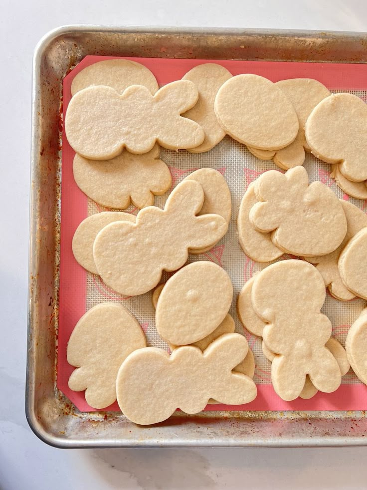 mickey mouse cut out cookies are on a baking sheet and ready to go into the oven