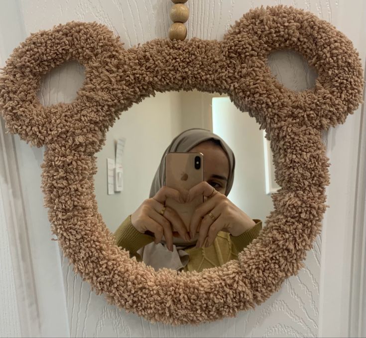 a woman taking a selfie in front of a mickey mouse mirror with her cell phone