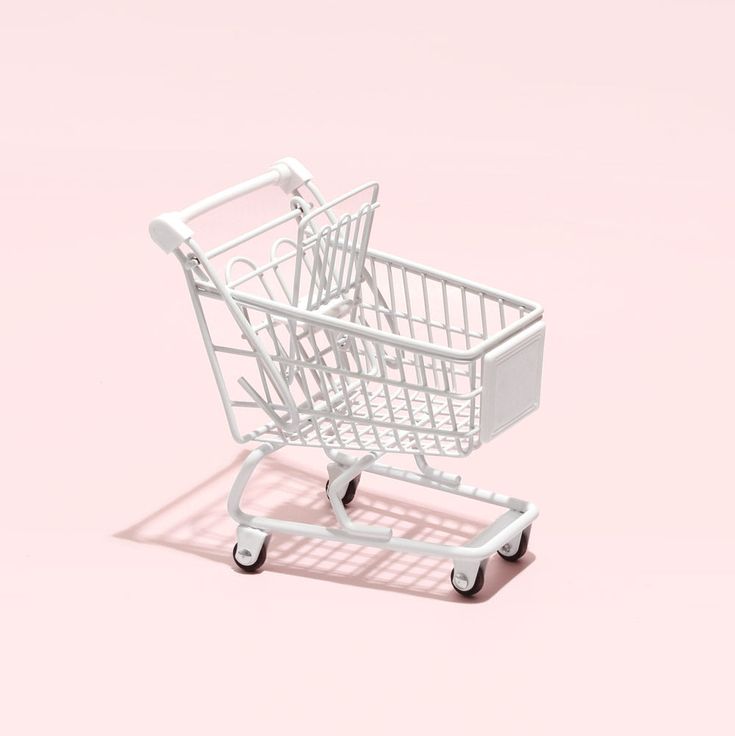 a white shopping cart on a pink background