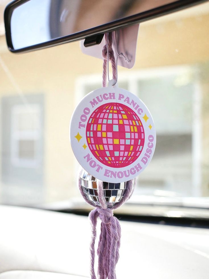 a mirror hanging from the side of a car with a sticker on it's handle