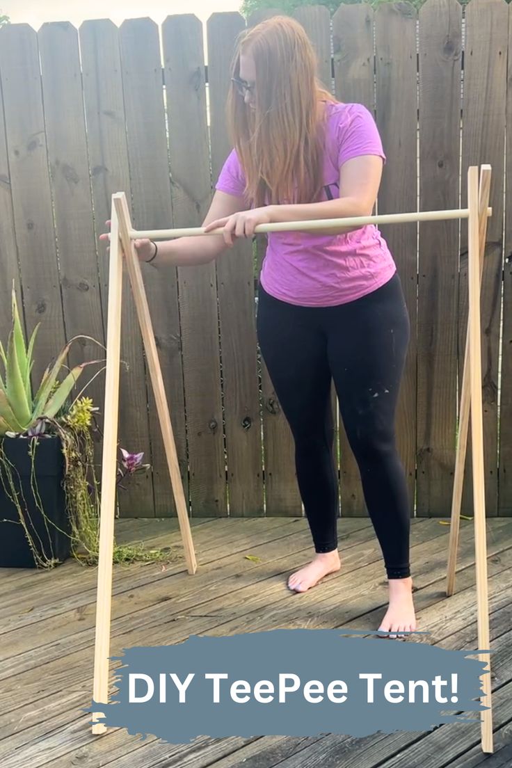 a woman standing on top of a wooden swing