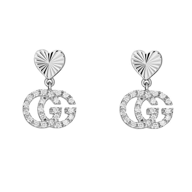 Crafted from precious white gold, these Gucci GG Running earrings pairs a contemporary House code with one of the brand's most recognizable emblems. Guccio Gucci's monogram appears as a diamond encrusted charms, paired with engraved heart studs. The combination not only pays tribute to Gucci's roots, but also connects different chapters of House history. 18k white gold 46 diamonds, totaling approximately .17 carats For pierced ears Heart studs Double G pendant with diamonds Length: .9" Made in I Classic Gucci Earrings For Anniversary, Gucci Fine Jewelry With Diamond Accents, Gucci Jewelry With Diamond Accents For Gift, Gucci White Gold Jewelry With Diamond Accents, Gucci Sterling Silver Earrings For Formal Occasions, Gucci White Gold Sterling Silver Earrings, Gucci Luxury Sterling Silver Earrings, Luxury Gucci Sterling Silver Earrings, Luxury Pierced Diamond Earrings For Anniversary