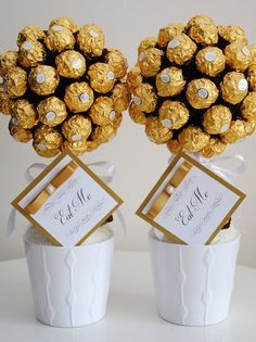 two white buckets filled with chocolate covered candies and gold foiled balls in them